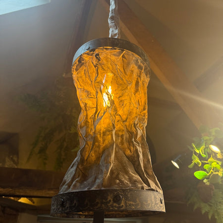 Vintage-style pendant light hanging indoors with a warm glow.