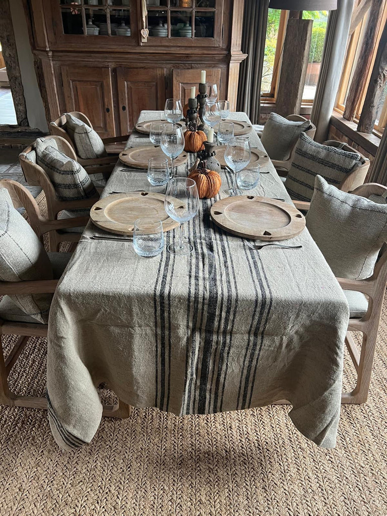 Rustic table setting on farmhouse kitchen table with orange pumpkin decorations and candles
