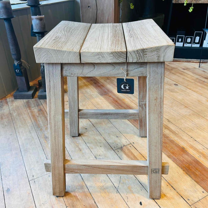 Teak bar stool with a visible brand tag on a wooden floor