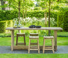 Wooden outdoor dining table with Gommaire Alexi Bar stools in a garden setting