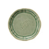 A round, antique-style stoneware plate with a green glaze and a leaf design in the center.