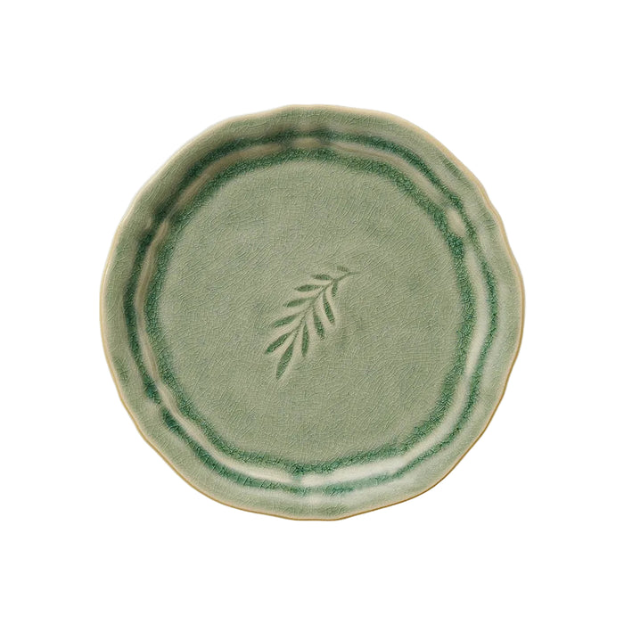 A round, antique-style stoneware plate with a green glaze and a leaf design in the center.