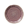 A round ceramic plate with a lavender glaze effect, featuring a simple leaf design in the center.