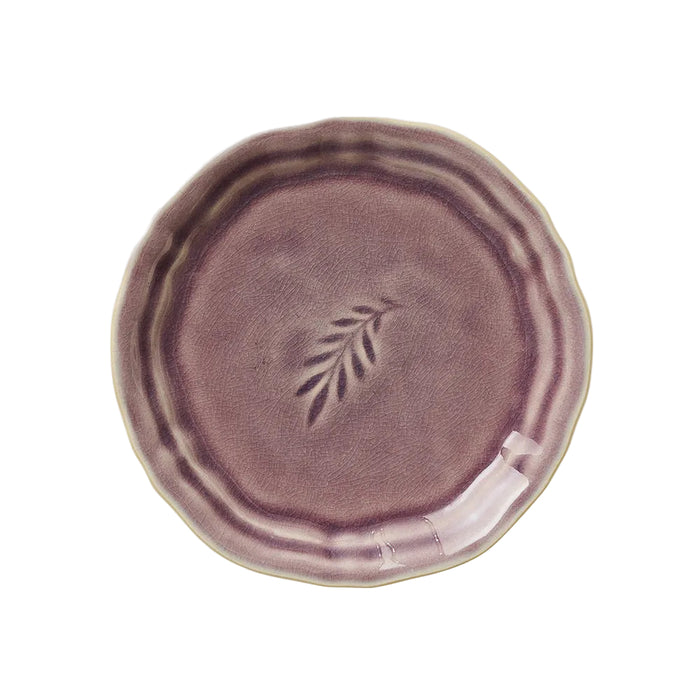 A round ceramic plate with a lavender glaze effect, featuring a simple leaf design in the center.