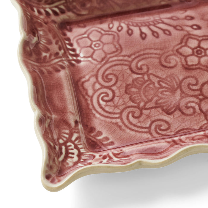 Close up of decorative glaze detail on appetiser plate in old rose colour by Sthal on a white background