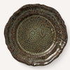 A decorative brown ceramic plate with an ornate floral pattern.