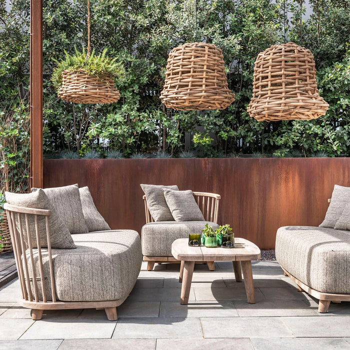 Outdoor patio set with chairs, table, and hanging planters in a garden setting.