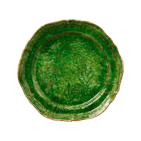 A green dinner plate with a wavy edge and floral pattern.