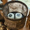 Drum shaped candle holder with metal and textured parchment-style surface 
