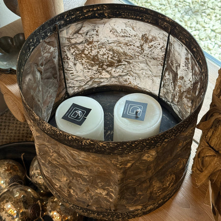 Drum shaped candle holder with metal and textured parchment-style surface 