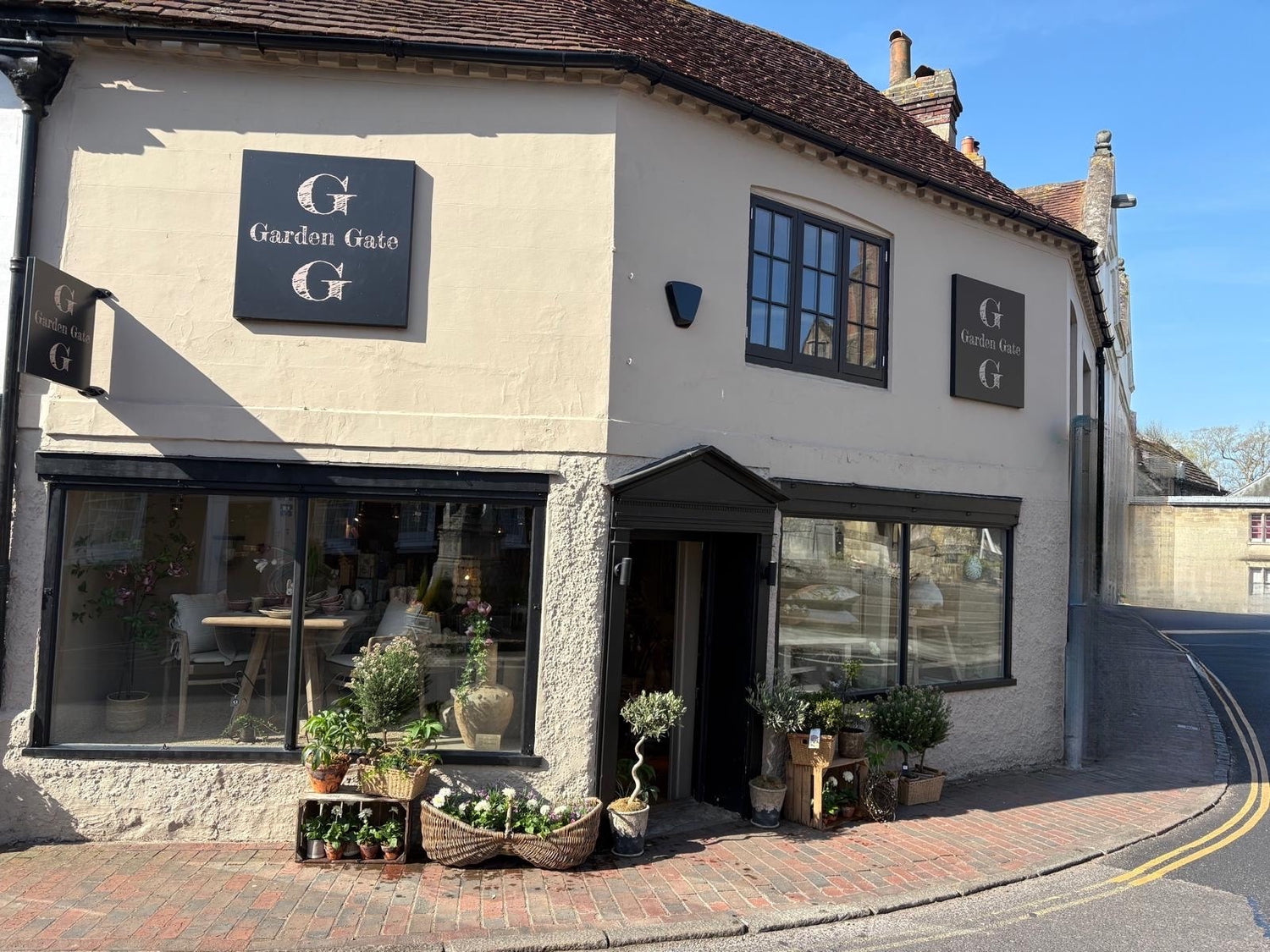 Storefront of home and lifestyle store called Garden Gate in Petworth with plants and flowers outside