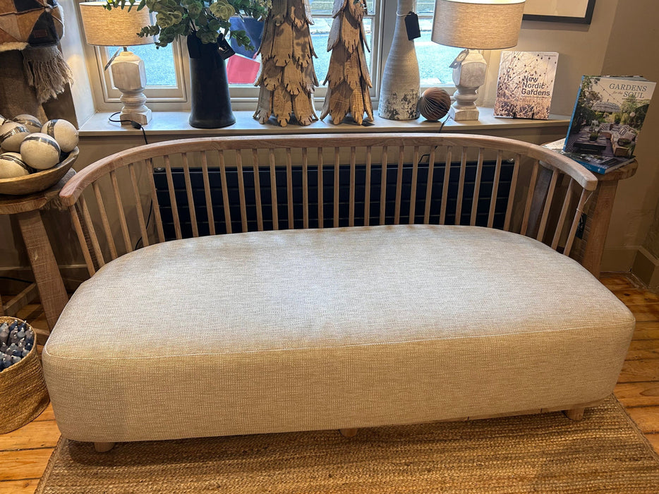 Teak Outdoor Sofa by Gommaire with deep cushion and curved back wooden rail by window in shop