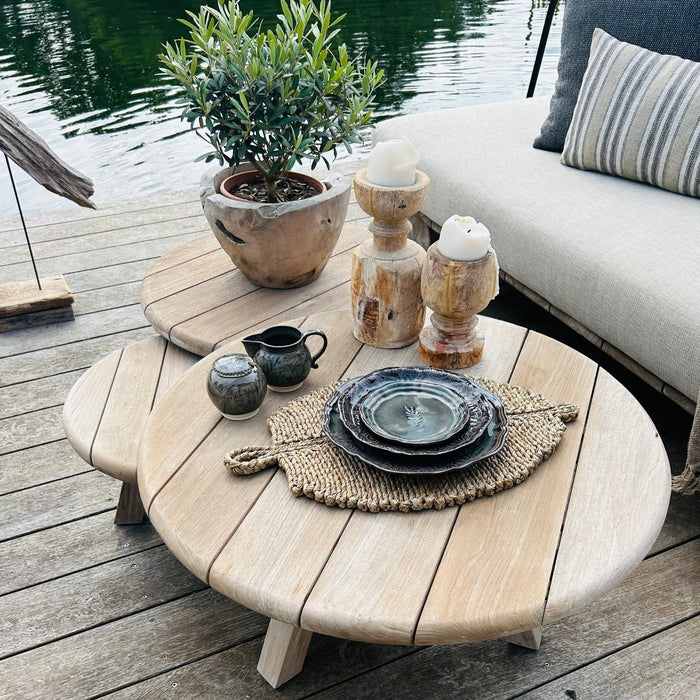 Trio of teak coffee tables in a lakeside setting with sofa 