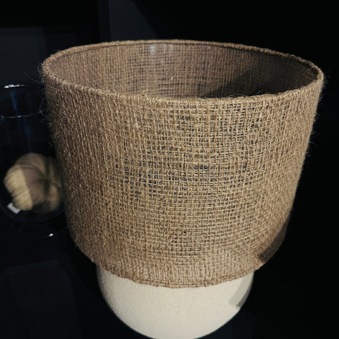 Textured brown lampshade on a cream base against a dark background