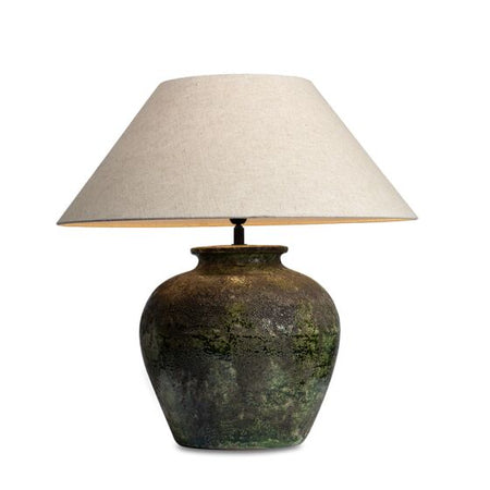Table lamp with textured base and beige lampshade on a white background