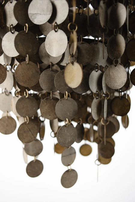 Close-up of a chandelier with round marble-effect discs on a white background
