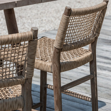Teak and woven rattan effect chairs on a wooden deck
