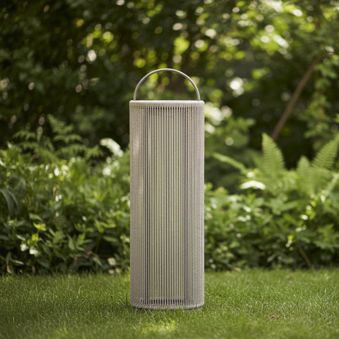 A tall cylindrical outdoor lantern with a woven beige rope body, a silver metal top handle, and a silver metal base, shown on a solid white background.