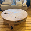 Low solid teak coffee table with rustic natural grooves and gaps in a shop setting