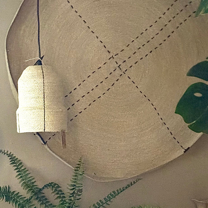 Seagrass Pendant Light against large seagrass wall tray in a living room with plants