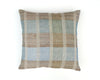 A cushion with a plaid pattern featuring shades of denim blue, sea green, and tobacco brown, made from linen and silk.