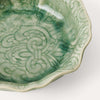 Close up of decorative glaze on small pale green ceramic bowl