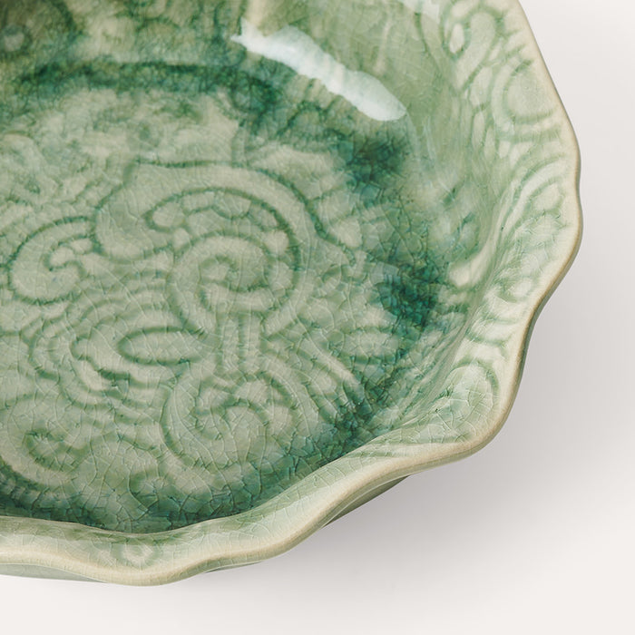 Close up of decorative glaze on small pale green ceramic bowl