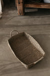 Shallow sea grass basket for storage or display placed on concrete floor