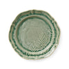 Green ceramic plate with leaf patterns on a white background