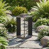 Decorative outdoor solar lantern with handle set against a natural background.