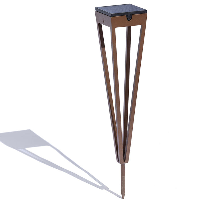 A modern corten aluminium solar torch pedestal with a square dark top, angled legs, and planting stake, shown on a white background with a cast shadow.