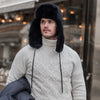 Man in street wearing black aviator sheepskin hat